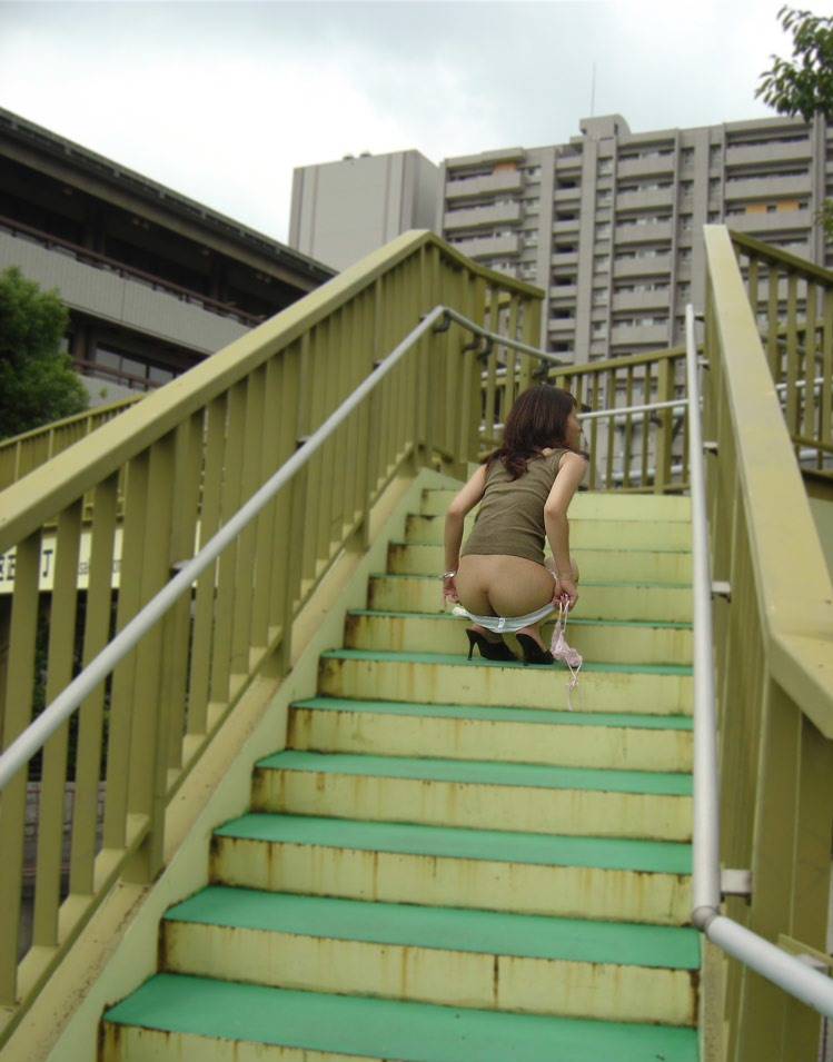 歩道橋の階段でスカート下ろして半ケツ状態の人妻！